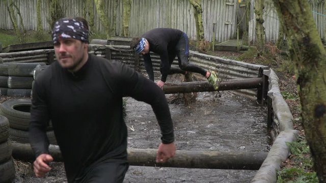 Men running through water in Mud run obstacle course / assault course - Slow motion - Stock Video Clip Footage