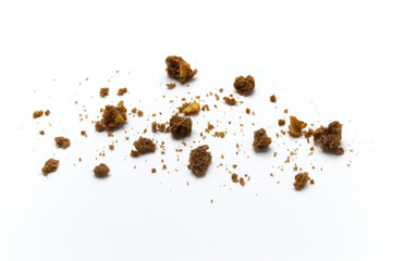 Scattered crumbs of chocolate chip butter cookies on white background.
