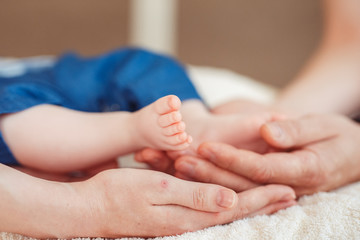 Close up photo of a baby foot in mother hands.