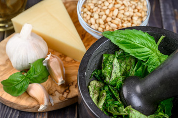 Preparation of basil pesto sauce with the main ingredients: fresh basil leaves, parmesan cheese, pine nuts, garlic