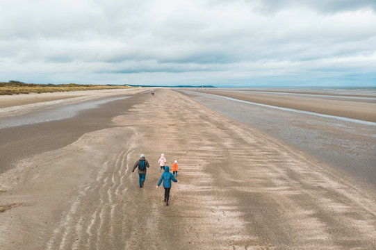 family running on beach