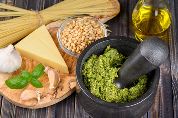 Preparation of basil pesto sauce with the main ingredients: fresh basil leaves, parmesan cheese, pine nuts, garlic