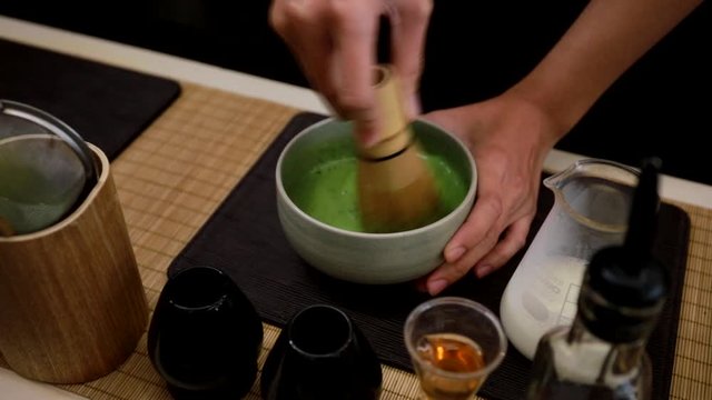 Matcha green tea making by stir the tea in a cup in Japanese style