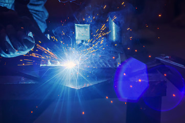 Metal welding in metal workshop. Clear light, blue tinting