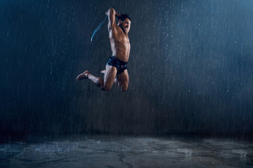 Wet shirtless gladiator jumping in attack.