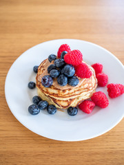 pencakes with peanut butter and fresh blueberries and raspberries