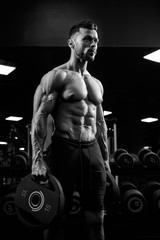 Fototapeta na wymiar Monochrome portrait of bodybuilder holding weights.