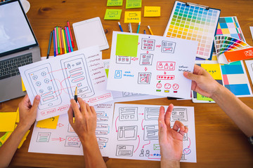 Obraz premium The web designer team is helping to design applications for mobile phones. UX UI designer concept
