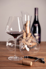 red wine glasses, bottle, corkscrew, decanter, corks