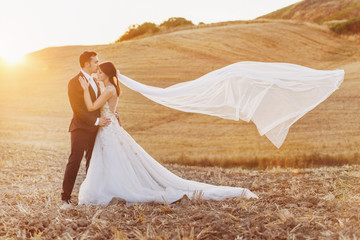 beautiful bride and groom in the field of tuscany