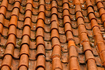 Prague. 05.10.2019: Low light detail of patina red roof top. Prague Lesser Town typical roofing material. Old roofing of clay tiles. Various orange shades and stains.