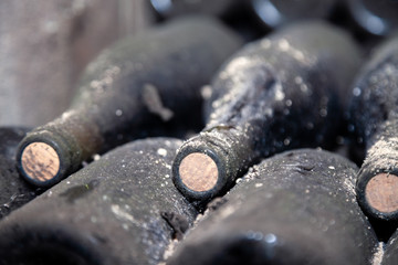 ancient dusty wine bottles with corks in cellar