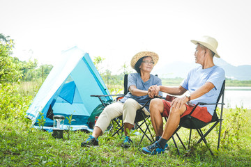 The elderly couple camping in the forest, happy to relax in retirement. Senior community concepts