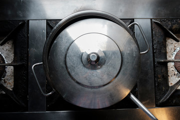 a gray metal saucepan with a lid on the stove