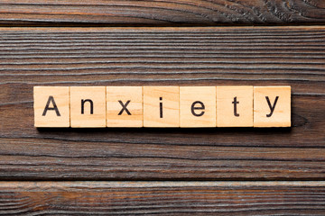 Anxiety word written on wood block. Anxiety text on wooden table for your desing, Top view concept