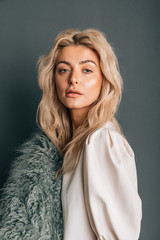 Fototapeta premium Portrait of wonderful young blonde woman with long hair looking at camera, smiling. Fashion stylish beauty portrait with blonde hair. Beautiful Girl's Face Close-up. Haircut. Hairstyle. Fringe.