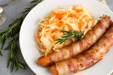 fried sausages with bacon on a plate.