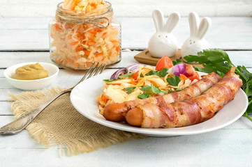 fried sausages with bacon on a plate.