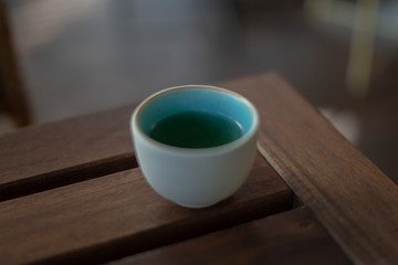 A cup of tea placed on a brown table , above view