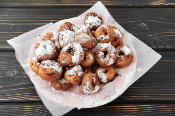 curd rings with topping from powder in a plate on a wooden background