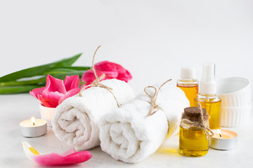 Fototapeta na wymiar Spa and wellness concept. Accessories for spa procedures towels, essential oils, candles and aromatic flowers. Skin care concept.