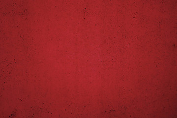 Texture of a dark red surface with dark dots and blackouts. Red background.