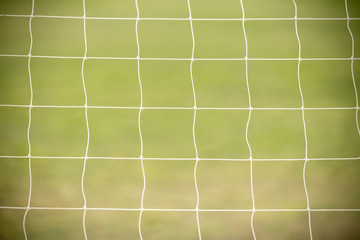 Close up of white football / soccer goal net with green grass as background using as sport wallpaper or background.