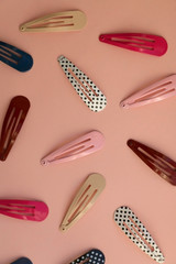 Colorful trendy hair clips on bright pink background. Top view.