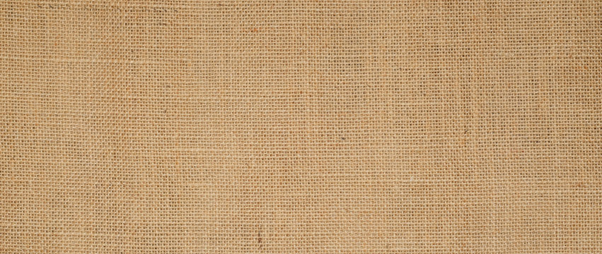Hessian sackcloth burlap woven texture background  / cotton woven fabric background with flecks of varying colors of beige and brown. with copy space. office desk concept.