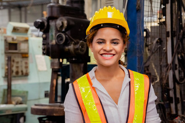 Portrait of a smile female mechanical engineer or employee worker with yellow safety helmet in a...