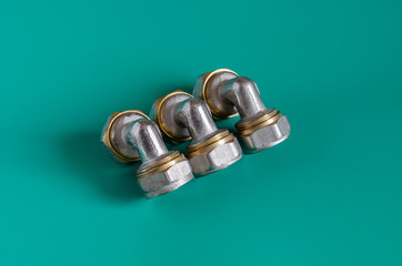 Corner fitting for multilayer pipes. Three assembled fittings on a green background. Accessories...