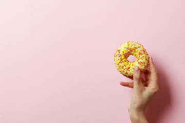 Fototapeta na wymiar Woman holding delicious donut on color background