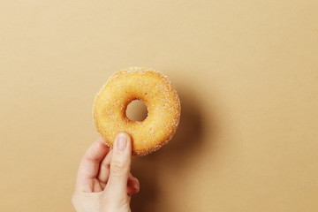 Woman holding delicious donut on color background