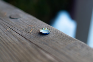 close up of isolated bottle top on wooden table with dramatic lighting