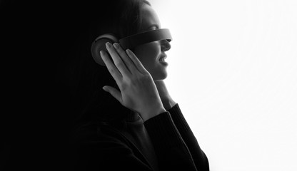 Beautiful woman in headphones listening music with closed eyes. Black and white. Free space for text.