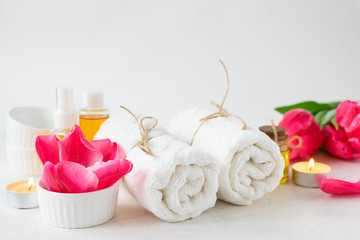 Spa and wellness concept. Spa accessories, candles, essential oils, aromatic flowers on white background with copy space for your design.