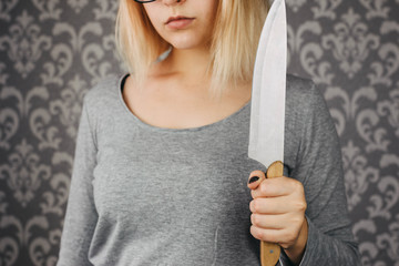 woman blonde holding a kitchen knife in her hand, threat, murder, domestic violence