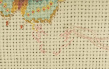 The initial stage of embroidery with floss threads on the canvas of a large picture with colorful...