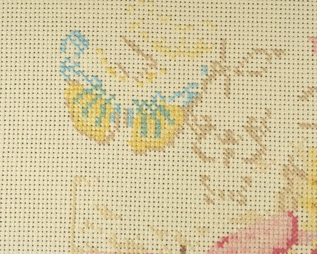 The initial stage of embroidery with floss threads on the canvas of a large picture with colorful butterflies. Hand made and hobby with a large amount of time.