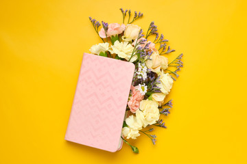 Pink Notepad with Flowers over yellow background. Spring mood