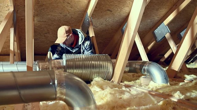 House Air Ventilation and Cleaning System Checking. Professional Installer Replacing Air Filter. on the Attic.
