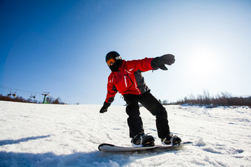 Young freerider on snowboarboard in action on slope