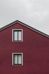 Fototapeta na wymiar Facade and roof of a dark red house
