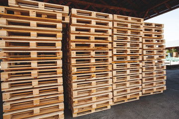 The multiple stacks of wooden pallets in the stock