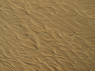 Patterns created by the receding water at low tide.