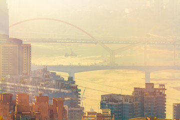 Blurred cityscape in sunset haze. Bridges over the Yangtze River in the Chinese city of Chongqing. For a beautiful background, postcard, banner.