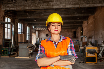 Portrait of woman in hard hat and protective gloves