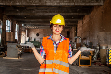 Charming woman in protective helmet welcoming to her working place