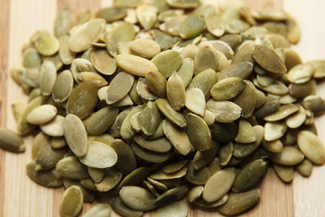 Dry raw pumpkin seeds lying slide on the table