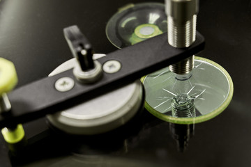 A mechanic uses repair equipment to repair a damaged windshield. It repairs glass chips with an injector under pressure and uses a special polymer.